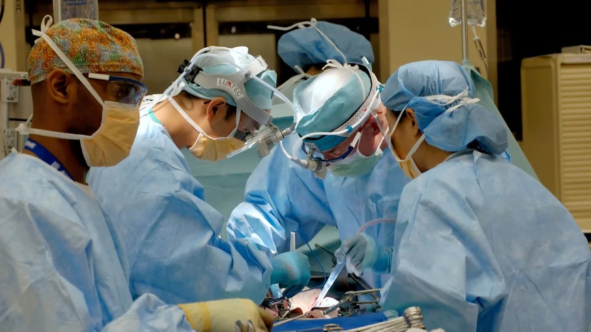Board-certified surgical team performing precision orthopedic procedure in sterile operating theater with advanced surgical navigation equipment